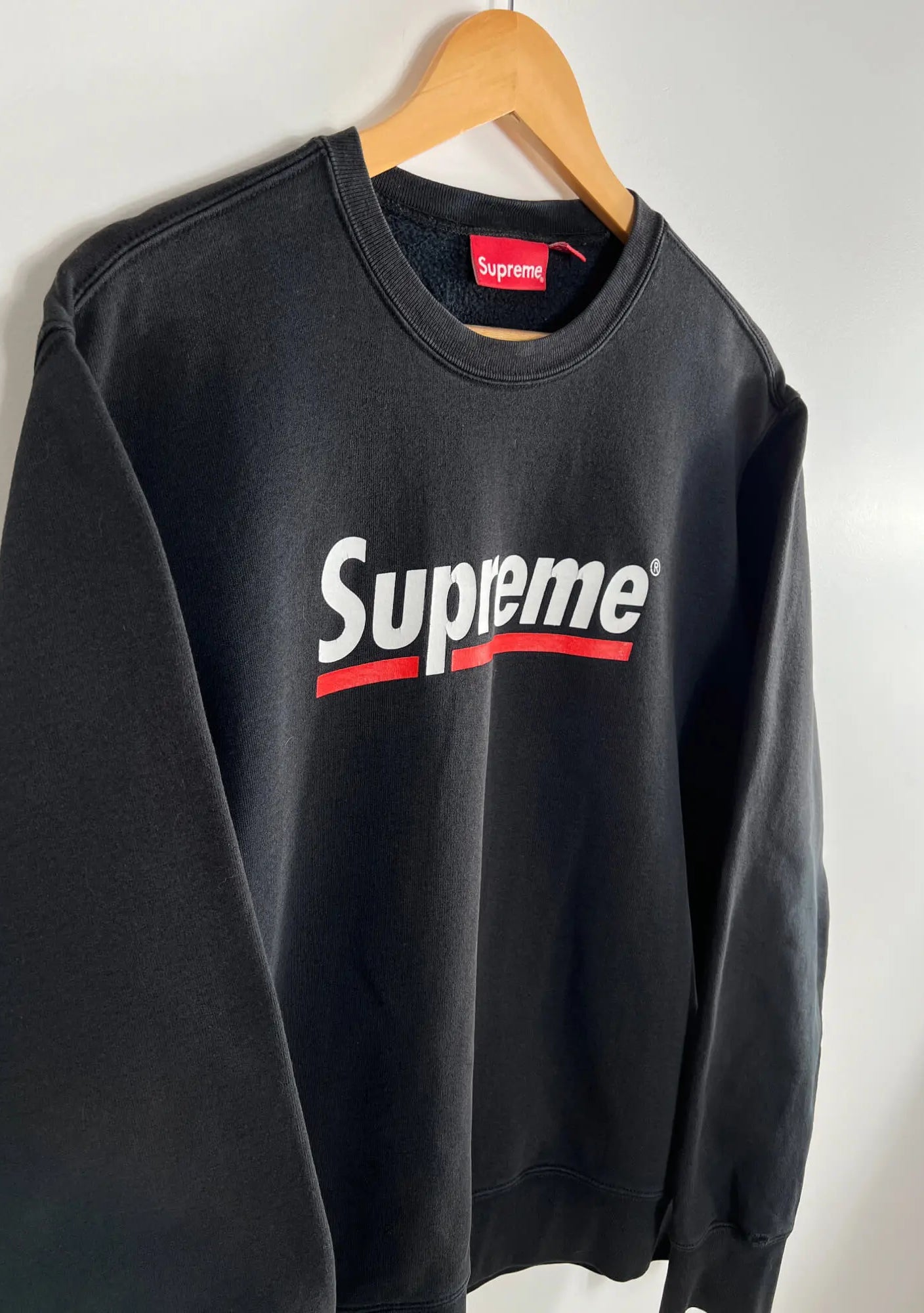 Supreme Underline Crewneck Noir SS20 vue du logo supreme
