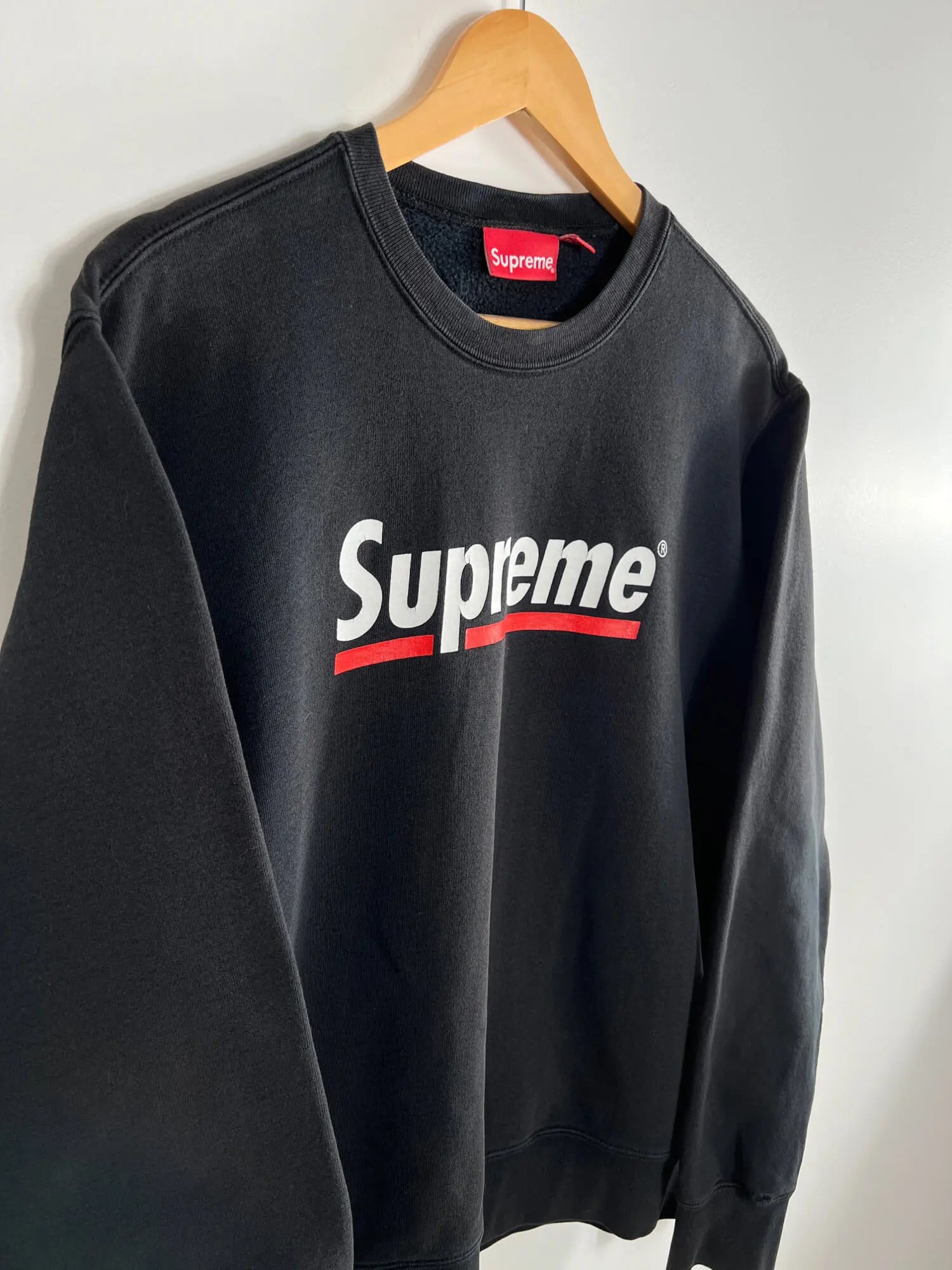 Supreme Underline Crewneck Noir SS20 vue du logo supreme