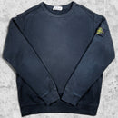 sweatshirt stone island noir avec le badge de la marque sur la manche gauche vue de face