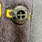 sweatshirt stone island noir avec le badge de la marque sur la manche gauche vue du bouton