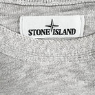 pull stone island gris avec le badge stone island sur la manche gauche vue de l'étiquette